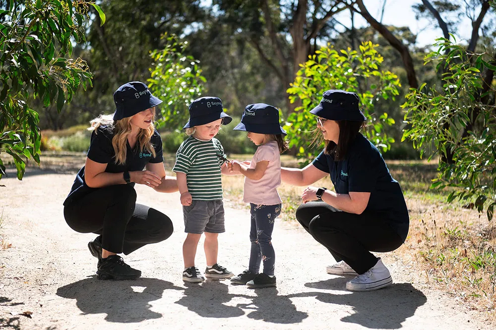 Early Childhood Educators with children in a natural learning environment at Beyond.