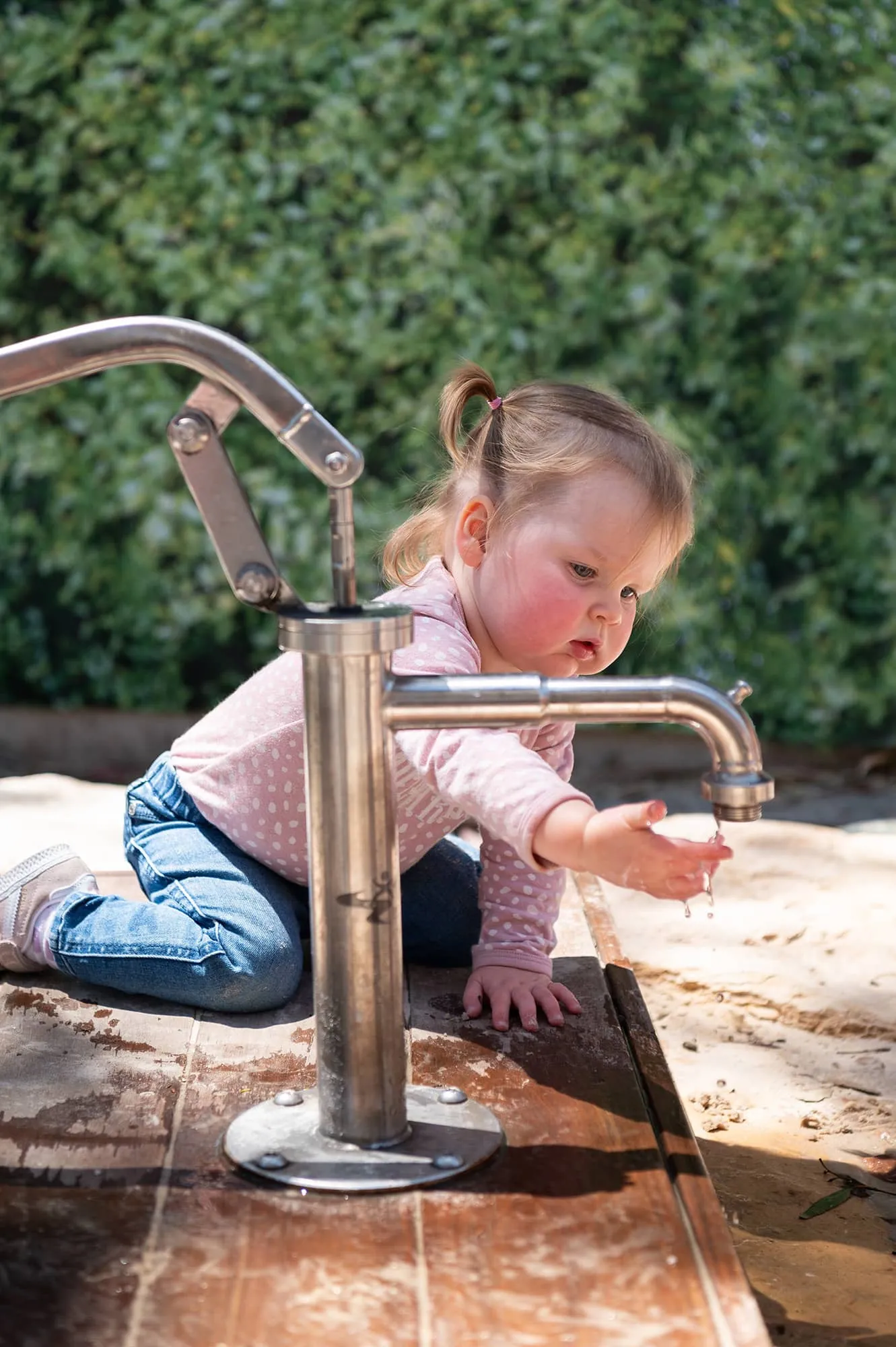 Toddler using water play to learn.