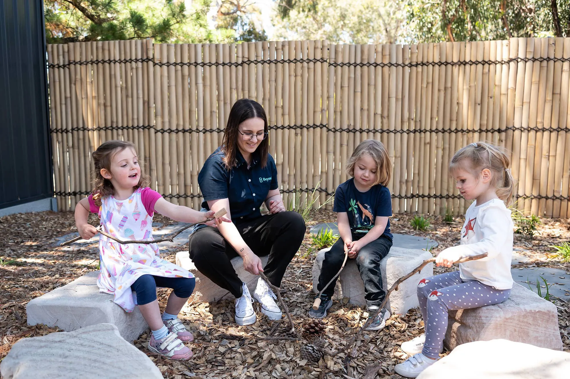 Children with an Early Childhood educator in an outdoor learning environment at Beyond.